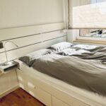 1. Schlafzimmer mit Doppelbett und Nachttisch. Links am Bett steht eine Nachttischlampe.
