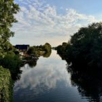 Blick auf das Dornumersieler Tief, das direkt am Garten der Ferienwohnung entlangfließt – ein Paradies für Angler und Wassersportler.