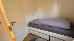 Zweites Schlafzimmer der Ferienwohnung mit komfortablem Einzelbett (90x200 cm) und offenem Fußteil – ideal für größere Gäste oder Jugendliche.